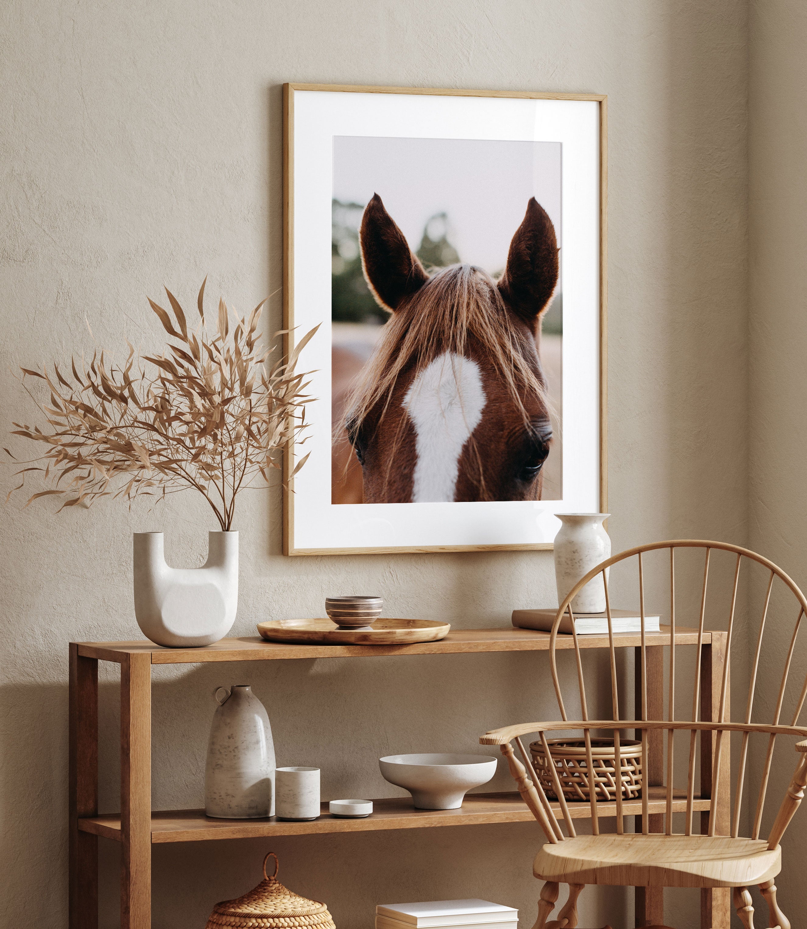 Photographic print of Benny the brown horse by Emily O'Brien, displayed on a frame with a chair in the background.